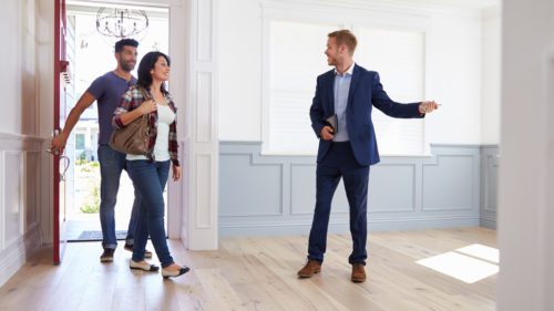 Couple and estate agent looking at new home; moving house