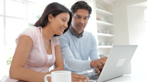 Couple using laptop to create a moving house checklist