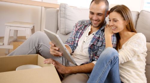 Couple using tablet to compare furniture removal prices